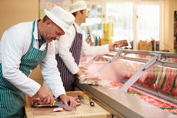 two butchers preparing meat in a butcher shop